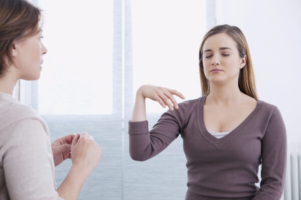 Hypnotised volunteer following suggestions that her arm is raising into the air